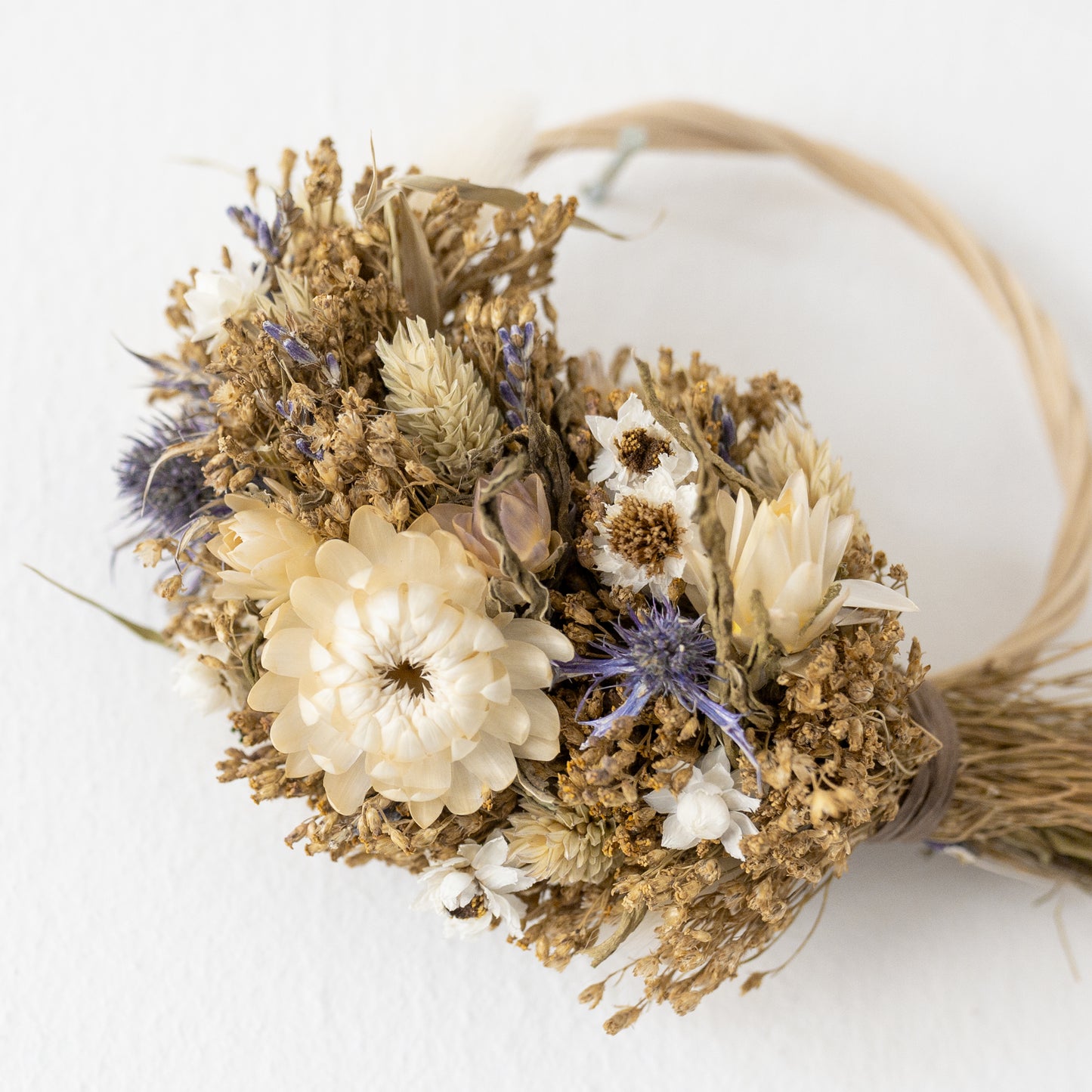 close up of a white strawflower on a mini wreath.
