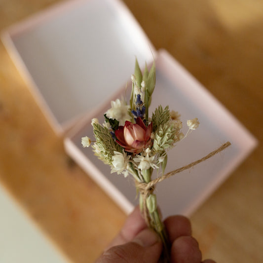 mini dried flower posy made of lavender, strawflower and grasses tied together with twine held in fingers