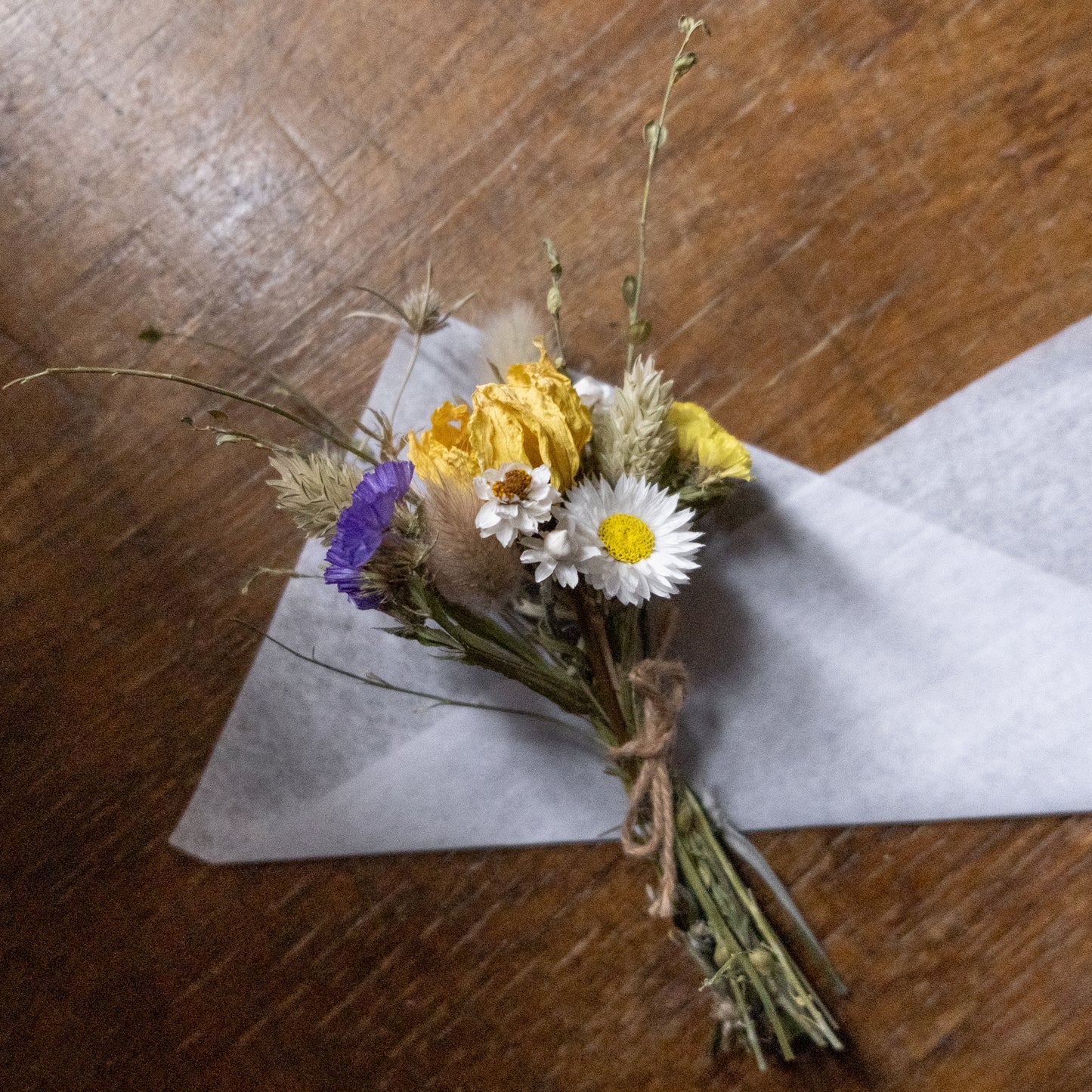 posy tied together with natural twine laid on white tissue paper 