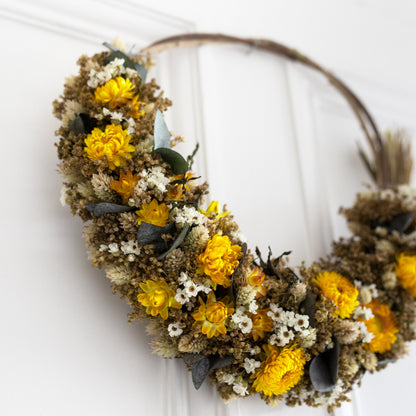 willow wreath close up of yellow strawflower, white daisies and eucalyptus