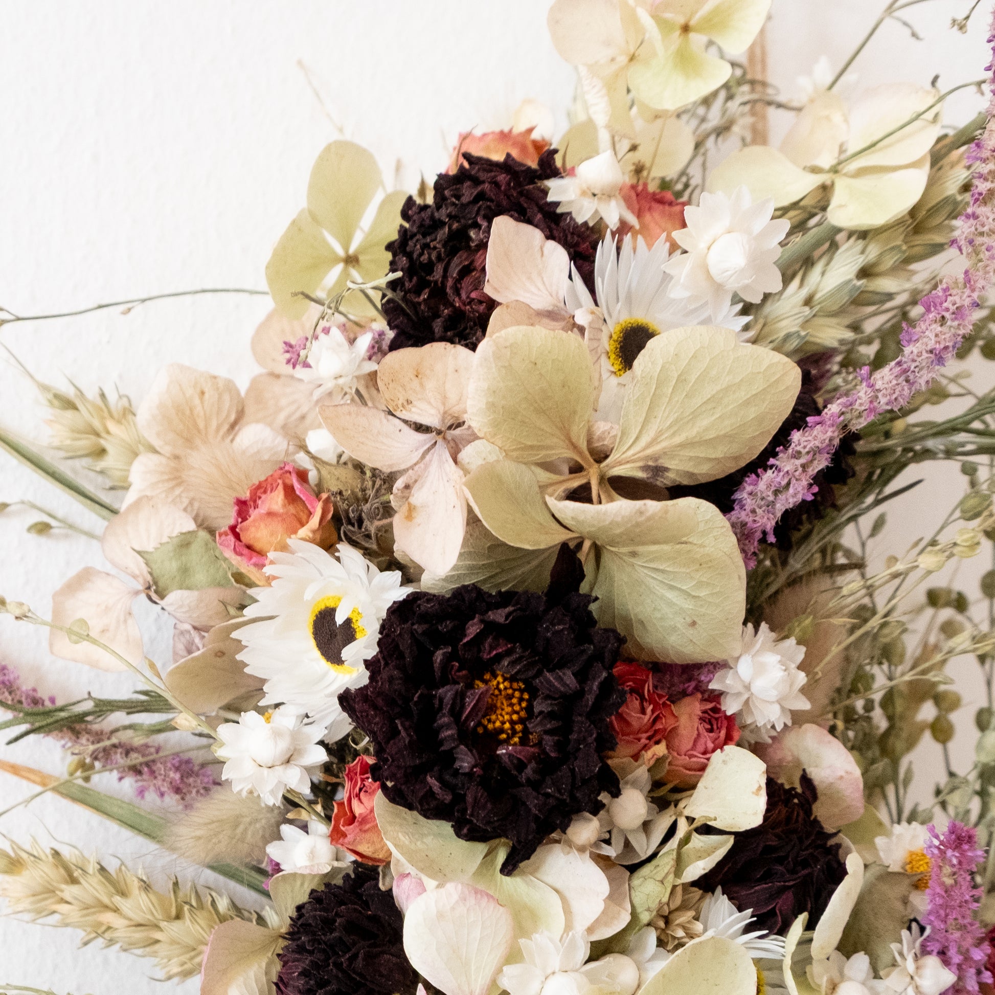 close up of dried flower wreath, close up of red dahlias, hydrangeas and roses
