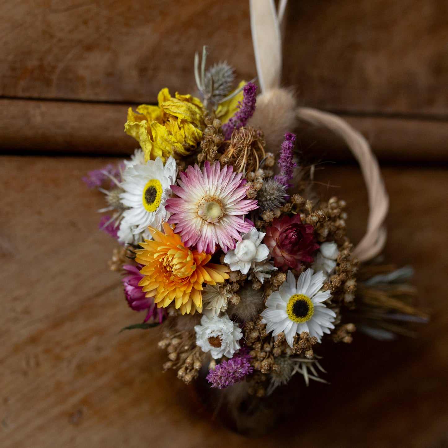 flower wreath close up of pink and yellow strawflowers with white winged daisies
